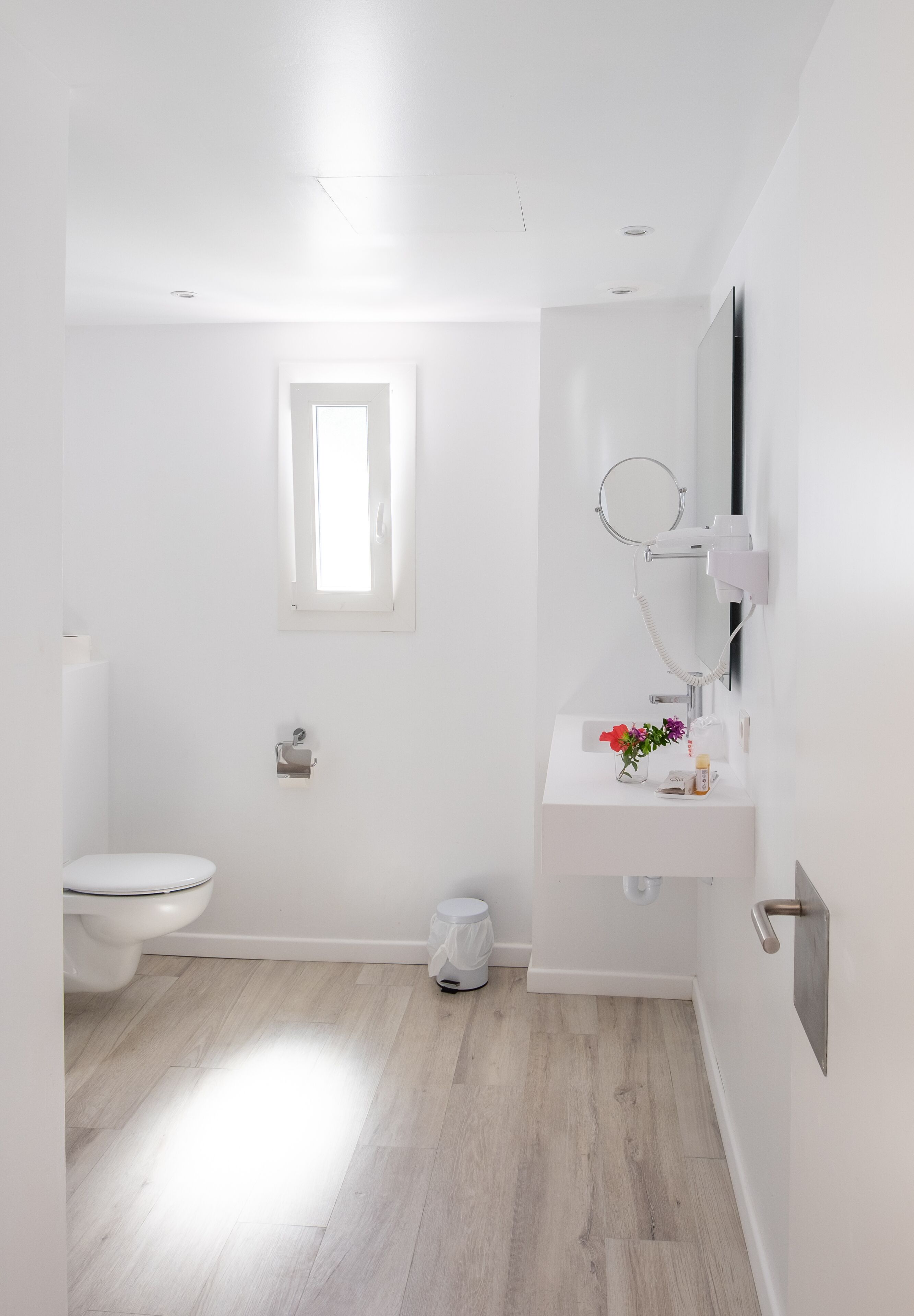 A modern bathroom with a toilet, sink, and mirror.