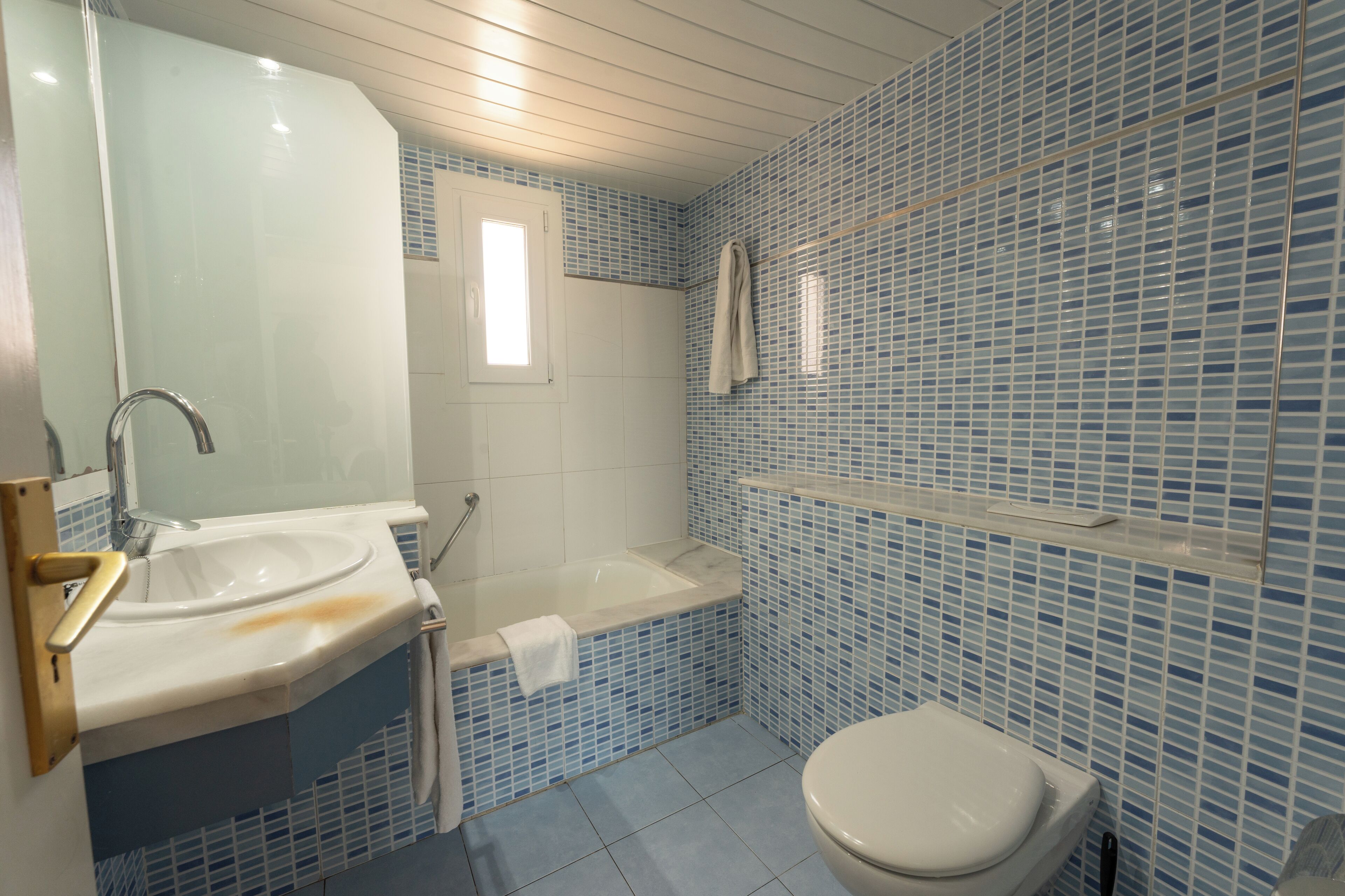 Een badkamer met een wastafel, bad en toilet.