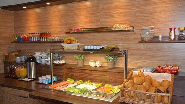A buffet area with various food items, a coffee station, and a display of condiments and beverages. - Altstadthotel Harburg (Hamburg)