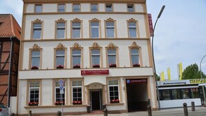 A hotel with a classic facade, a central entrance, and a visible parking sign. - Altstadthotel Harburg (Hamburg)