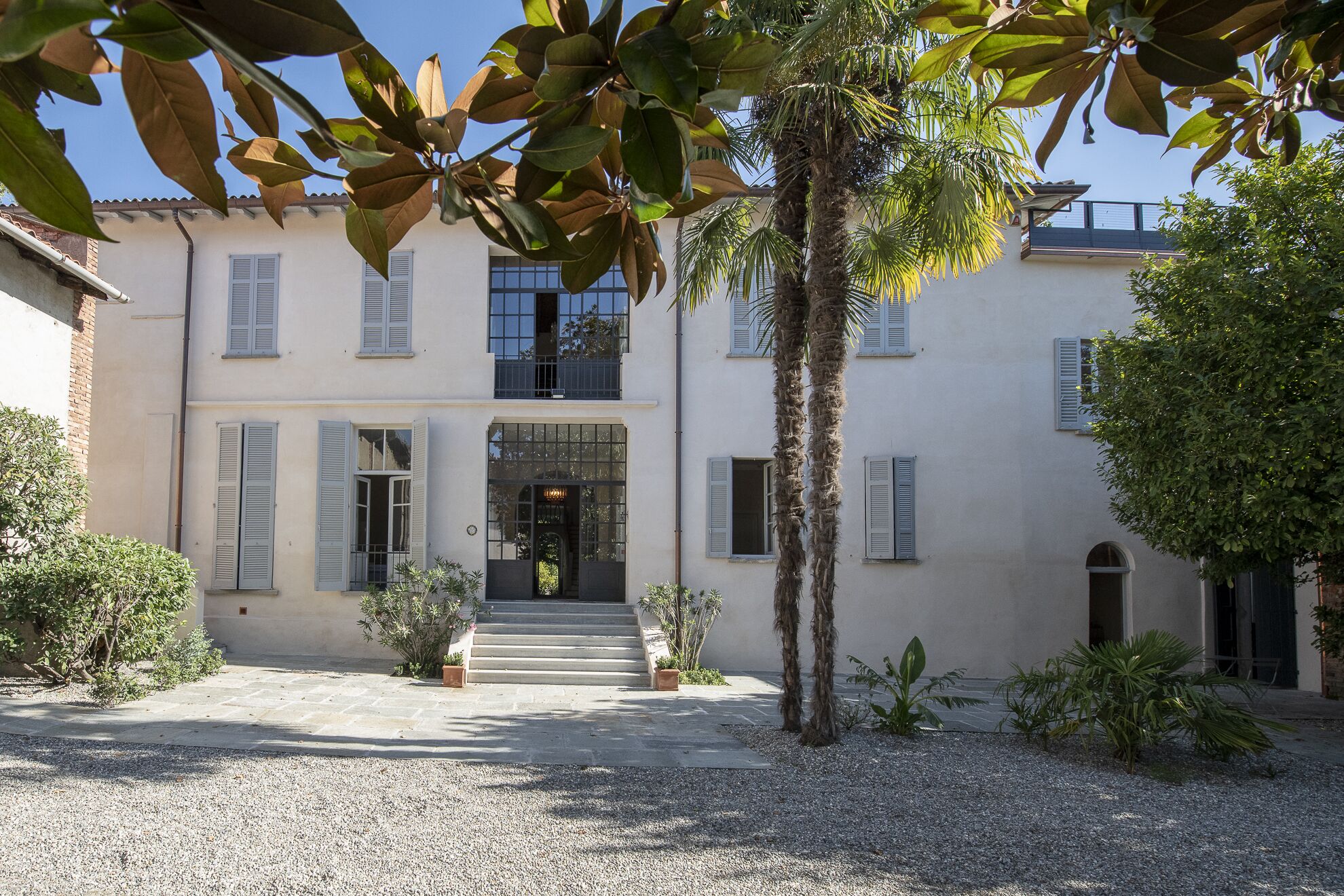Un bâtiment à deux étages doté d’une façade symétrique, avec une entrée centrale donnant sur un perron menant à une porte.