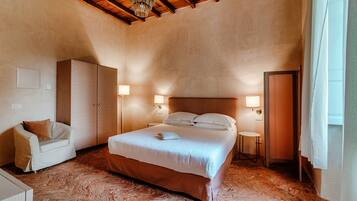 Une chambre à coucher avec un grand lit, une armoire, une chaise et deux lampes de chevet.