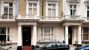 A multi-story building with a classic architectural style, featuring a symmetrical facade with evenly spaced windows and decorative moldings.