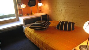 Una habitación con una cama, un escritorio y una ventana.