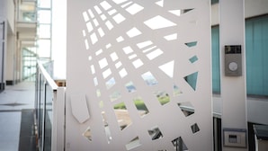 A modern building with a geometric patterned door and a security keypad. - Urban Relax (Favara)