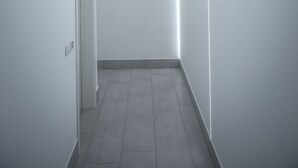 A modern, minimalist hallway with white walls and a tiled floor. - Urban Relax (Favara)