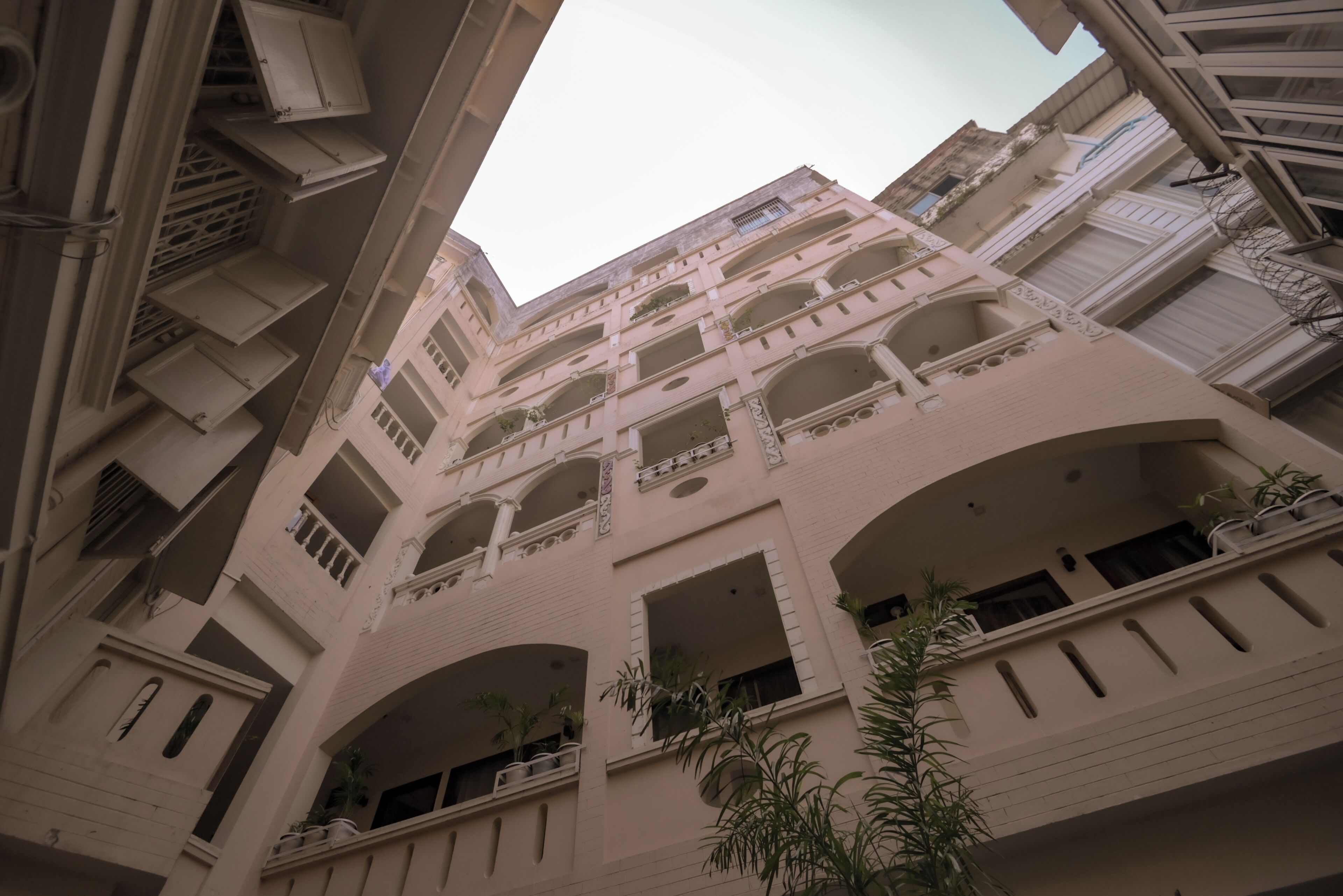 A multi-story building with balconies and arched windows.