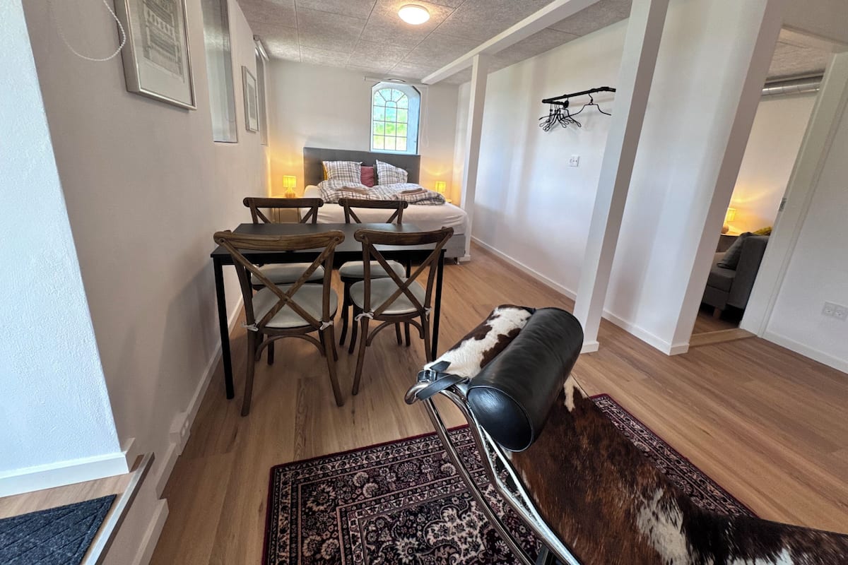 Ein modernes Interieur mit Essbereich, einer Couch und einem Flur, der zum Schlafzimmer führt.