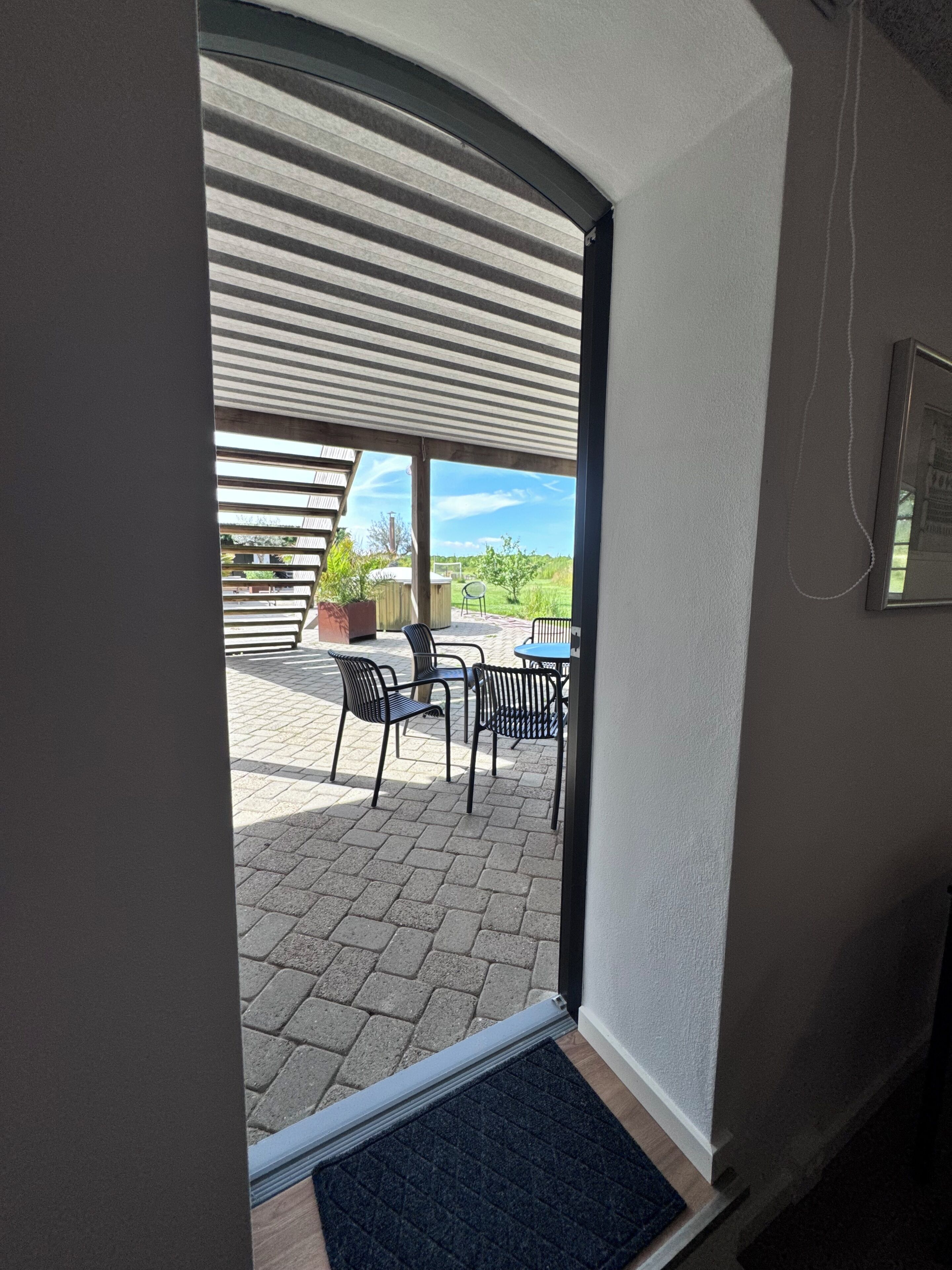 Un patio cubierto con mobiliario exterior y vistas del paisaje circundante.