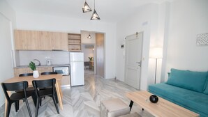 Une cuisine moderne avec des meubles en bois, une table à manger avec des chaises, un canapé et une petite table avec une lampe.
