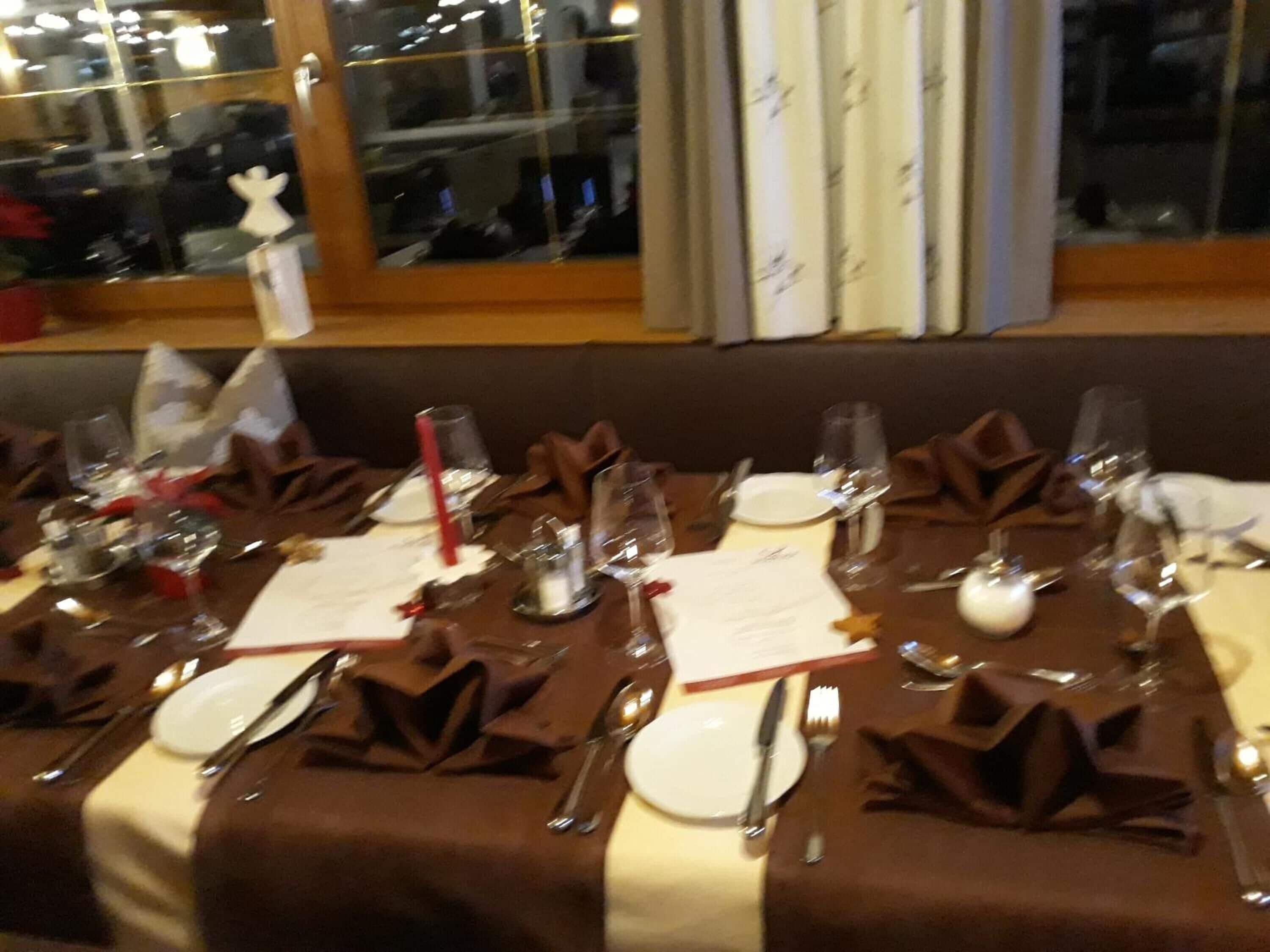 A dining table set for a meal with plates, cutlery, and glasses.