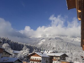Un pueblo de montaña con edificios nevados y un cielo azul despejado.