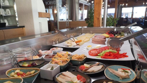 Ein Buffet mit verschiedenen Speisen, darunter Pasta, Fleischgerichte und Salate.