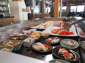 A buffet with various food items including pasta, meats, and salads.