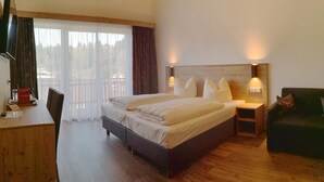 Ein Schlafzimmer mit einem hölzernen Bett, zwei Nachttischen mit Lampen, einem Schreibtisch und einem Stuhl.