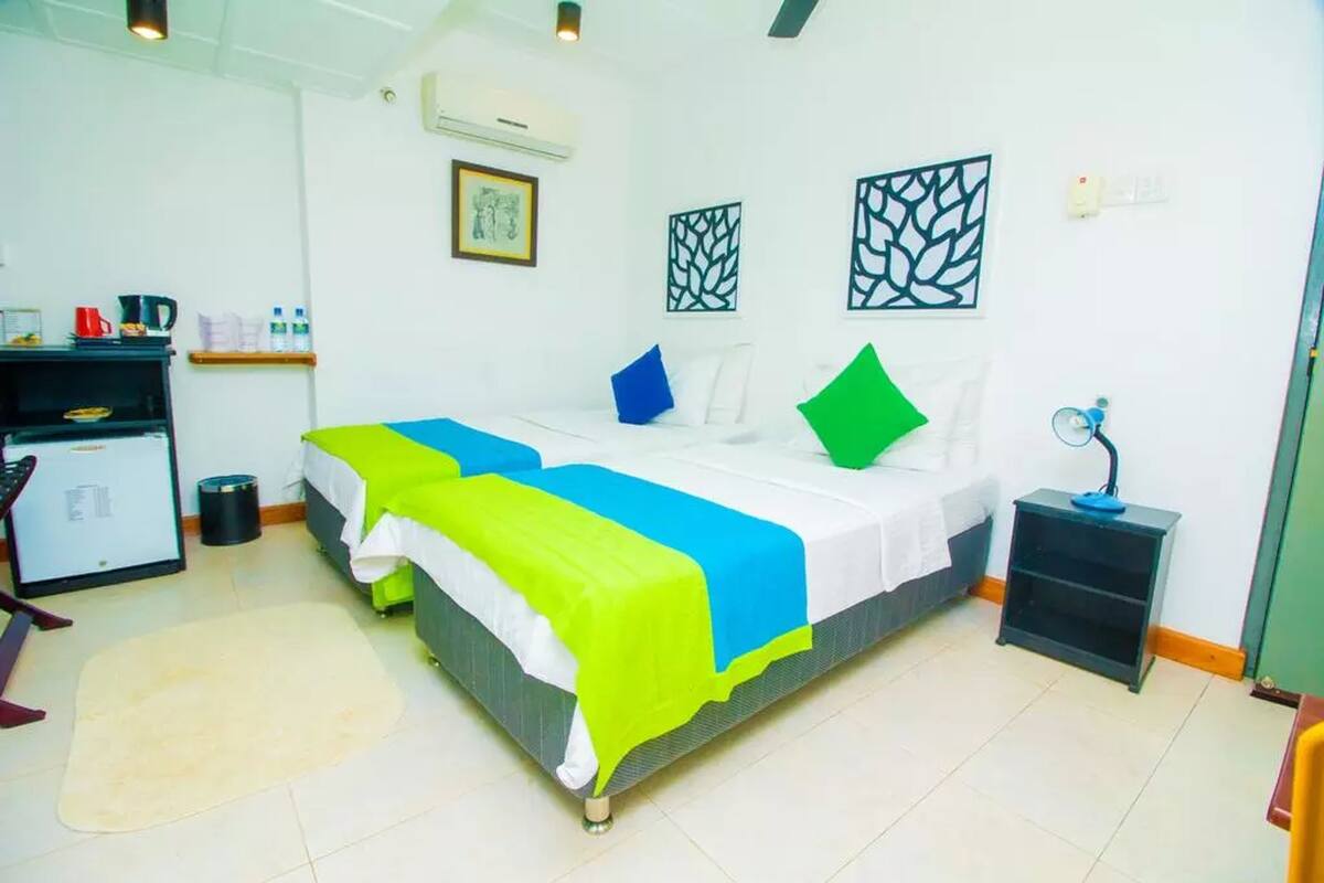 A neatly arranged bedroom with a bed, bedside table, and a desk with a chair.