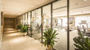 A modern gym with exercise equipment, glass walls, and potted plants. - Holiday Inn Hotel and Suites Suzhou Yangcheng Lake by IHG (Suzhou)