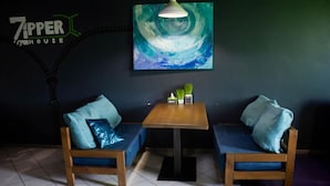 Una habitación con dos sofás de madera, una mesita y un cuadro colgado en la pared.