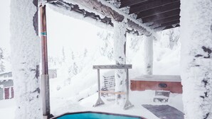 A snow-covered outdoor area with a hot tub and a wooden deck. - Little Peak (Kuusamo)