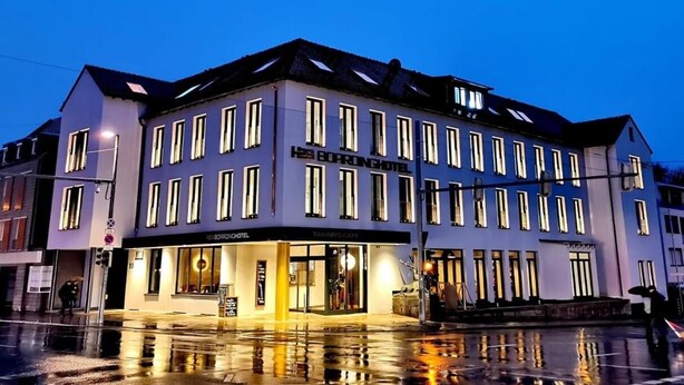 A multi-story hotel with a modern facade, large windows, and a ground-level restaurant. - H23 Boardinghotel (Stuttgart)