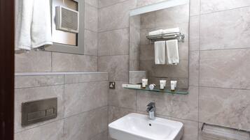 A bathroom with a white sink, a mirror, and a towel rack.