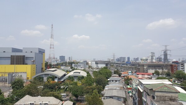A cityscape with various buildings, including a prominent yellow structure and a tall communication tower.