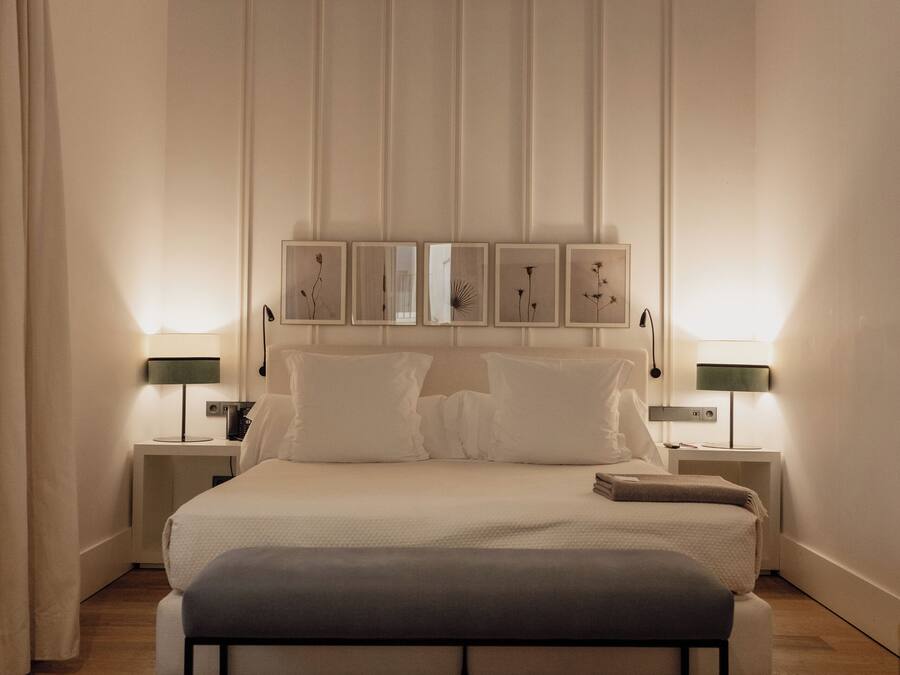 Une chambre moderne avec un grand lit, des tables de chevet avec des lampes et un plafond en bois.