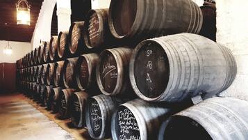 A row of stacked wine barrels in a cellar.