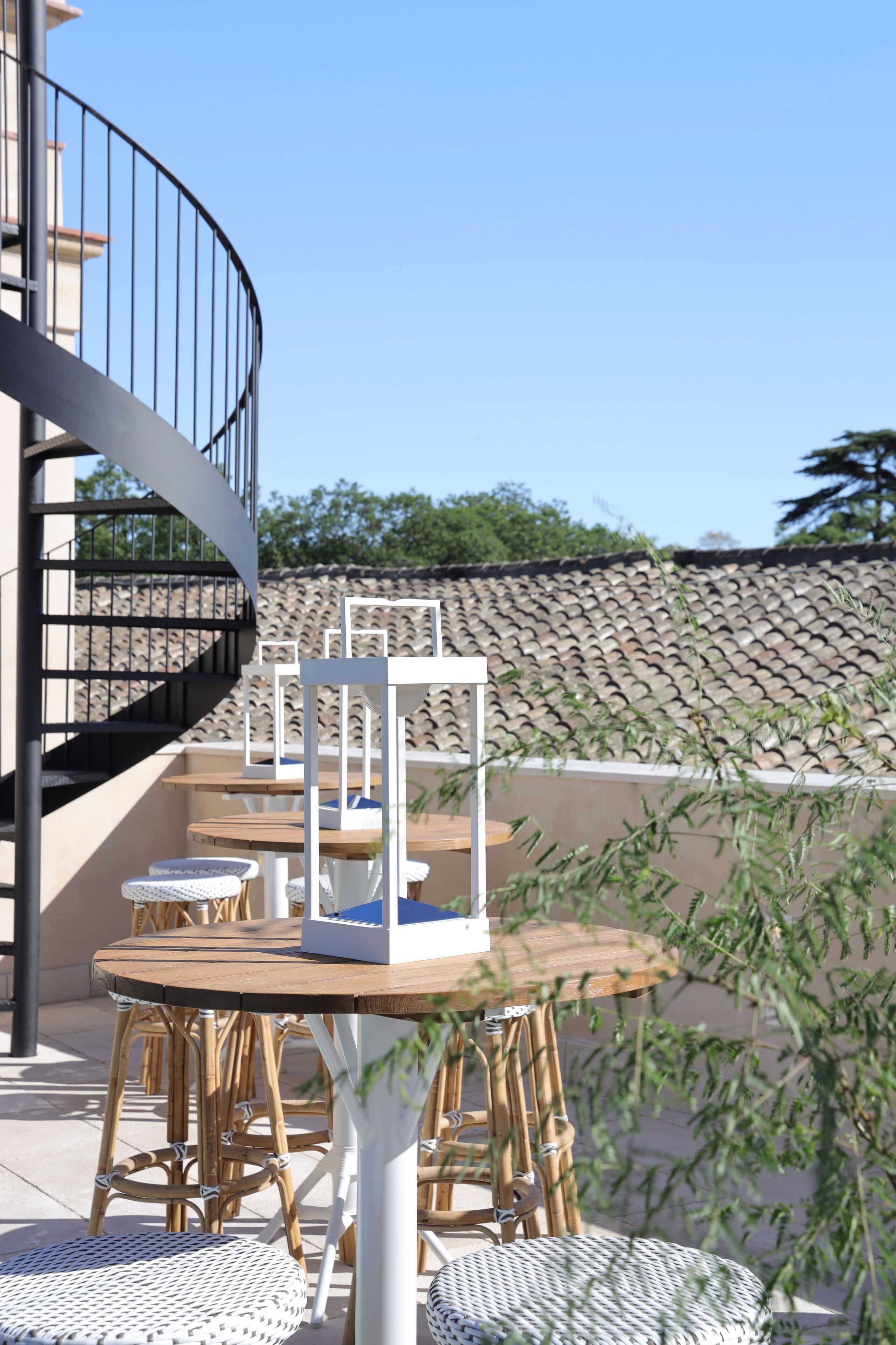 An outdoor seating area with wicker furniture and a spiral staircase.