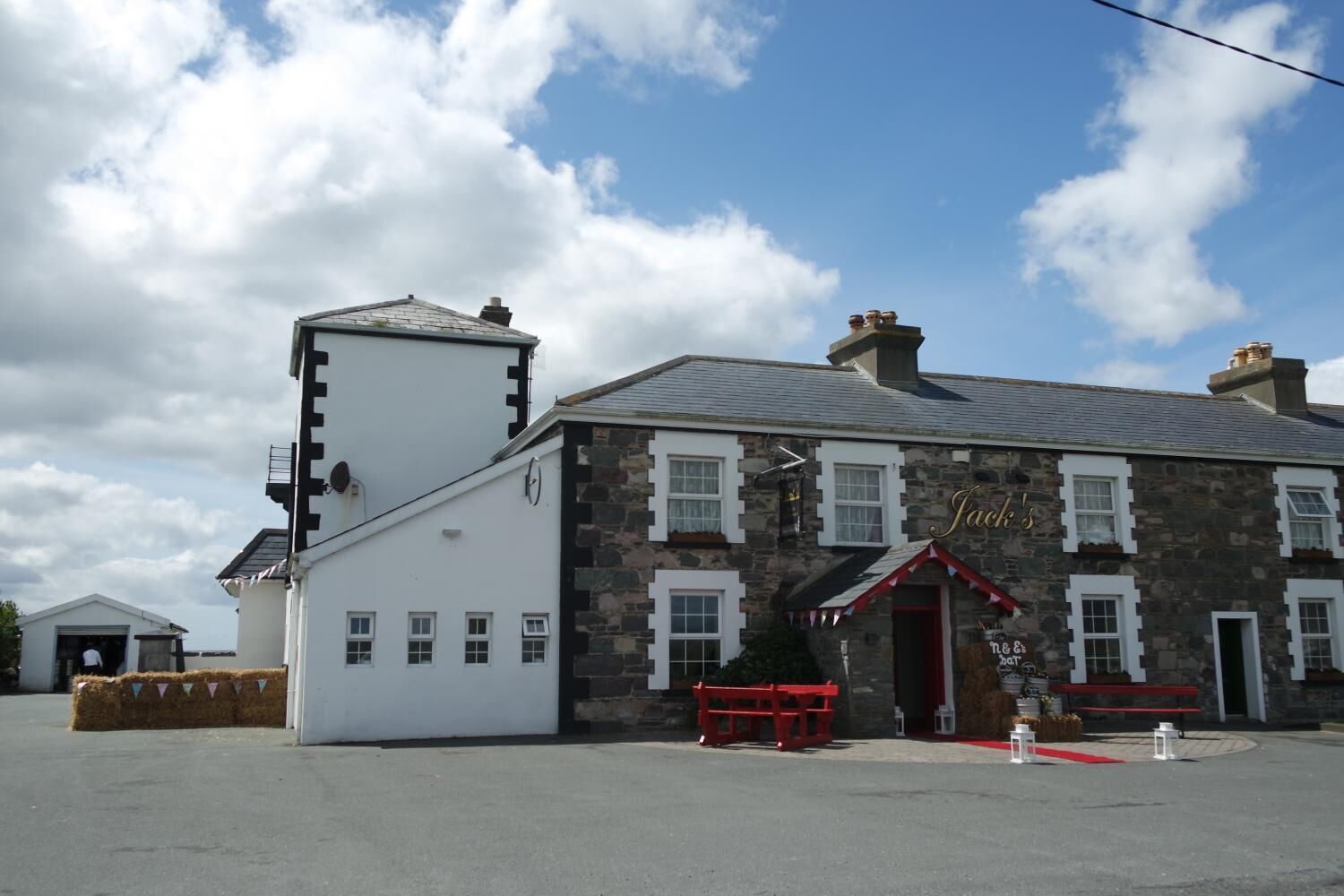 A stone building with a white annex, a red awning, and a sign reading "Jack's".