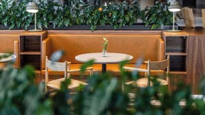 A modern seating area with a round table, cushioned benches, and two floor lamps. - Comfort Hotel Copenhagen Airport (Kastrup)
