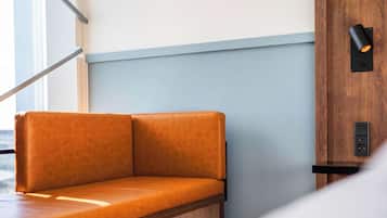 Un espacio de descanso moderno con un banco de madera y una lámpara fijada a la pared.