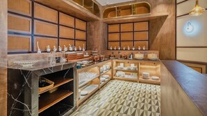 A modern kitchen with a marble countertop, wooden shelves, and a geometric patterned floor. - Manxin Hotel Qingdao Zhanqiao (Qingdao)