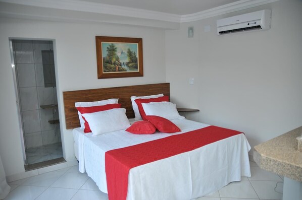 Une chambre d’hôtel équipée d’un lit, d’une douche et d’un appareil de climatisation.