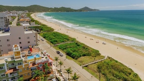 Na praia, areia branca, guarda-sóis 