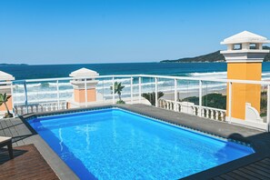 Una piscina al aire libre, sombrillas, tumbonas