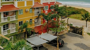 Un hotel frente al mar con edificios coloridos, vista a la playa y zona de estacionamiento.