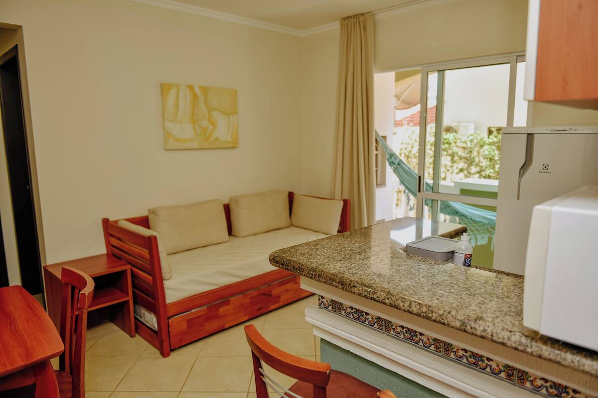 A compact living space with a kitchenette, a sofa bed, and a dining area.
