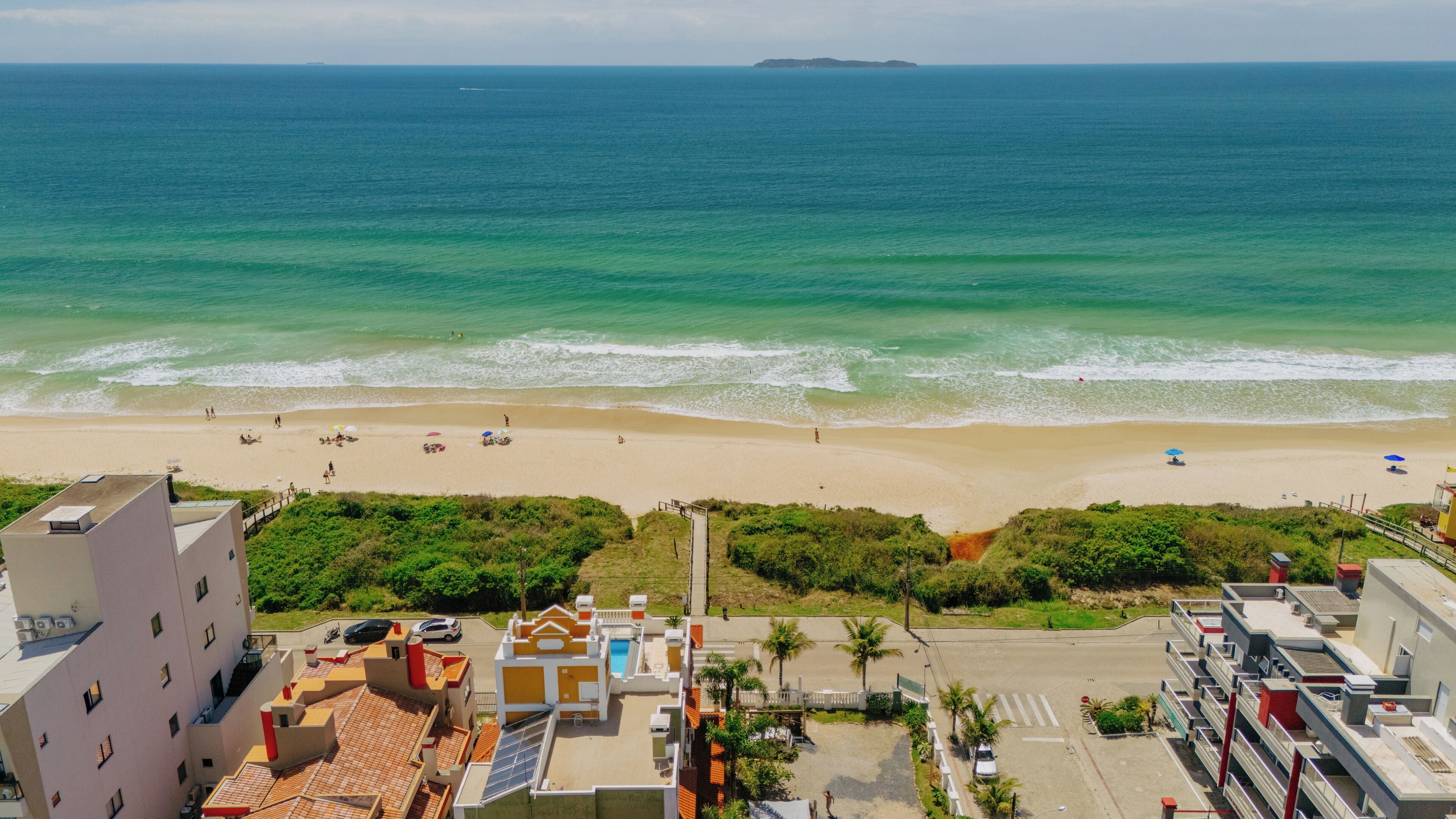 Na praia, areia branca, guarda-sóis 