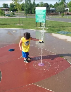 A child playing with a water fountain on a playground. - Discovery Park House (Wheat Ridge)