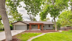 A single-story house with a garage, a covered porch, and a well-maintained lawn. - Discovery Park House (Wheat Ridge)