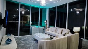 Un salon moderne avec un canapé, une table basse et une lampe.