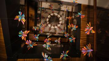 A room with a large mirror reflecting colorful paper flowers.