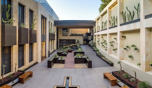 A modern building with a central courtyard featuring planters and benches.