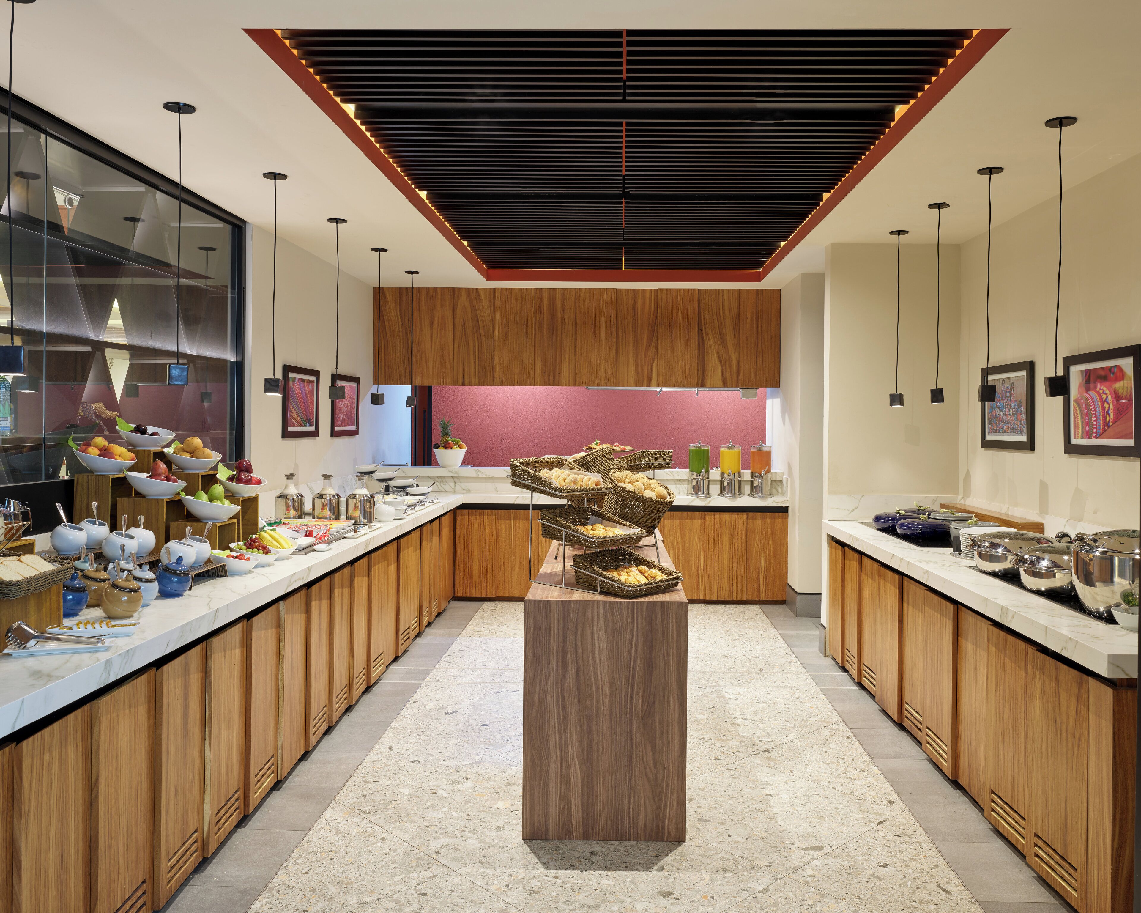 A modern kitchen with wooden cabinets, a central island, and a variety of food items and kitchenware.