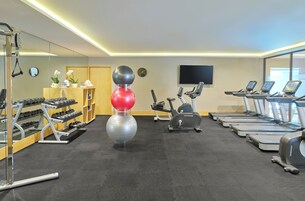 Un gimnasio con cintas de correr, elípticas y pesas sueltas.