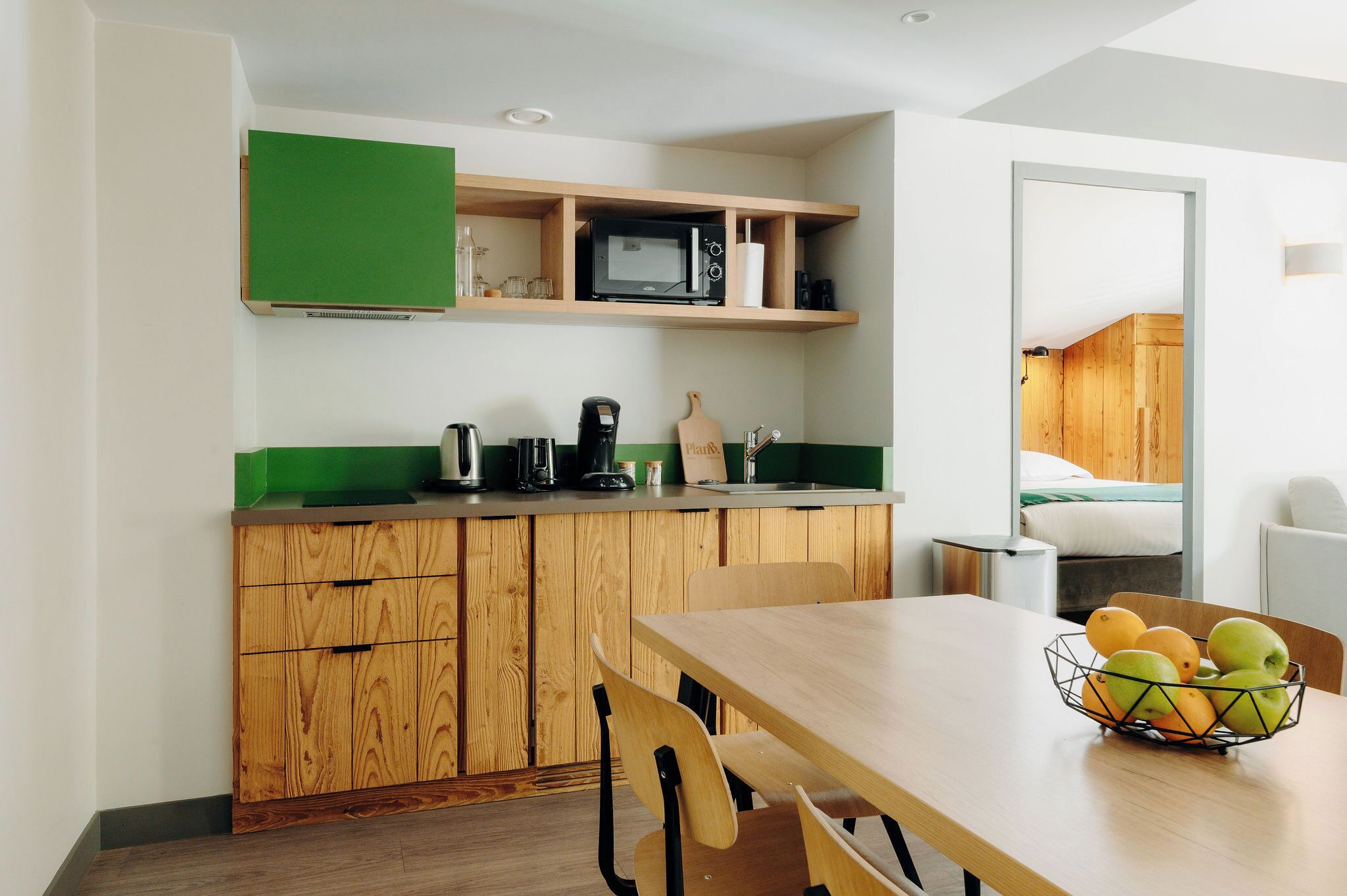 A compact kitchen with wooden cabinets, a microwave, and a coffee maker.