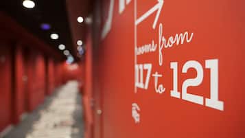 Ein Korridor mit roter Wand, auf der die Zahlen 117 bis 121 stehen, sowie ein Pfeil, der die Richtung weist.