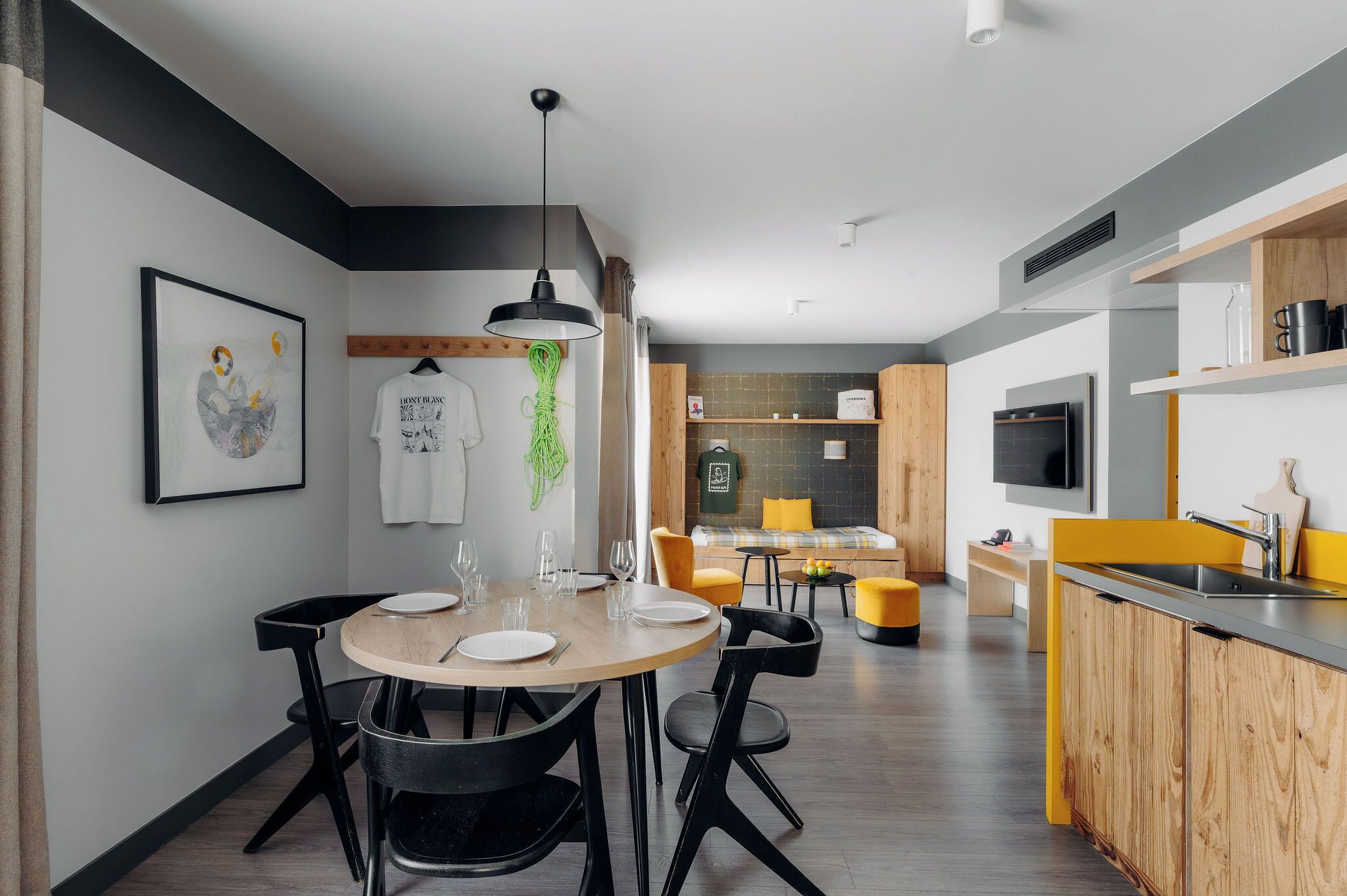 Una cocina moderna con comedor, armarios de madera y televisor.