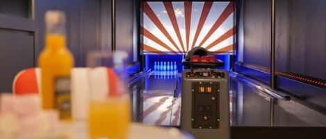 A bowling alley with a modern design, including a bowling ball return system and a neon-lit bowling lane.